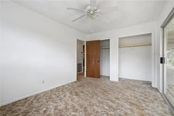 a view of a livingroom with wooden floor and a ceiling fan