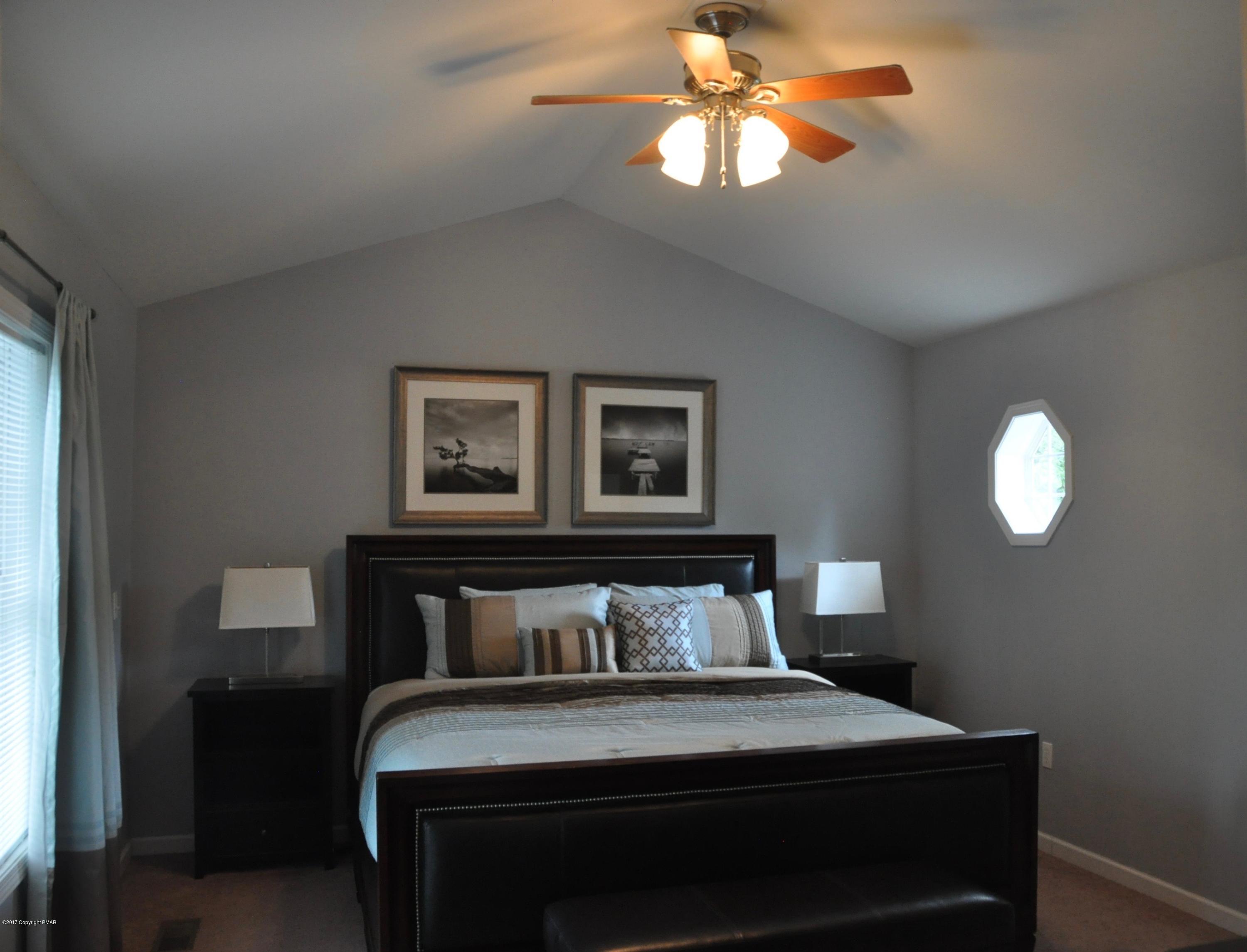 167 Sawmill Road Long Pond, PA 18334 - Photo 20 of 38 a bedroom with a bed and a chandelier