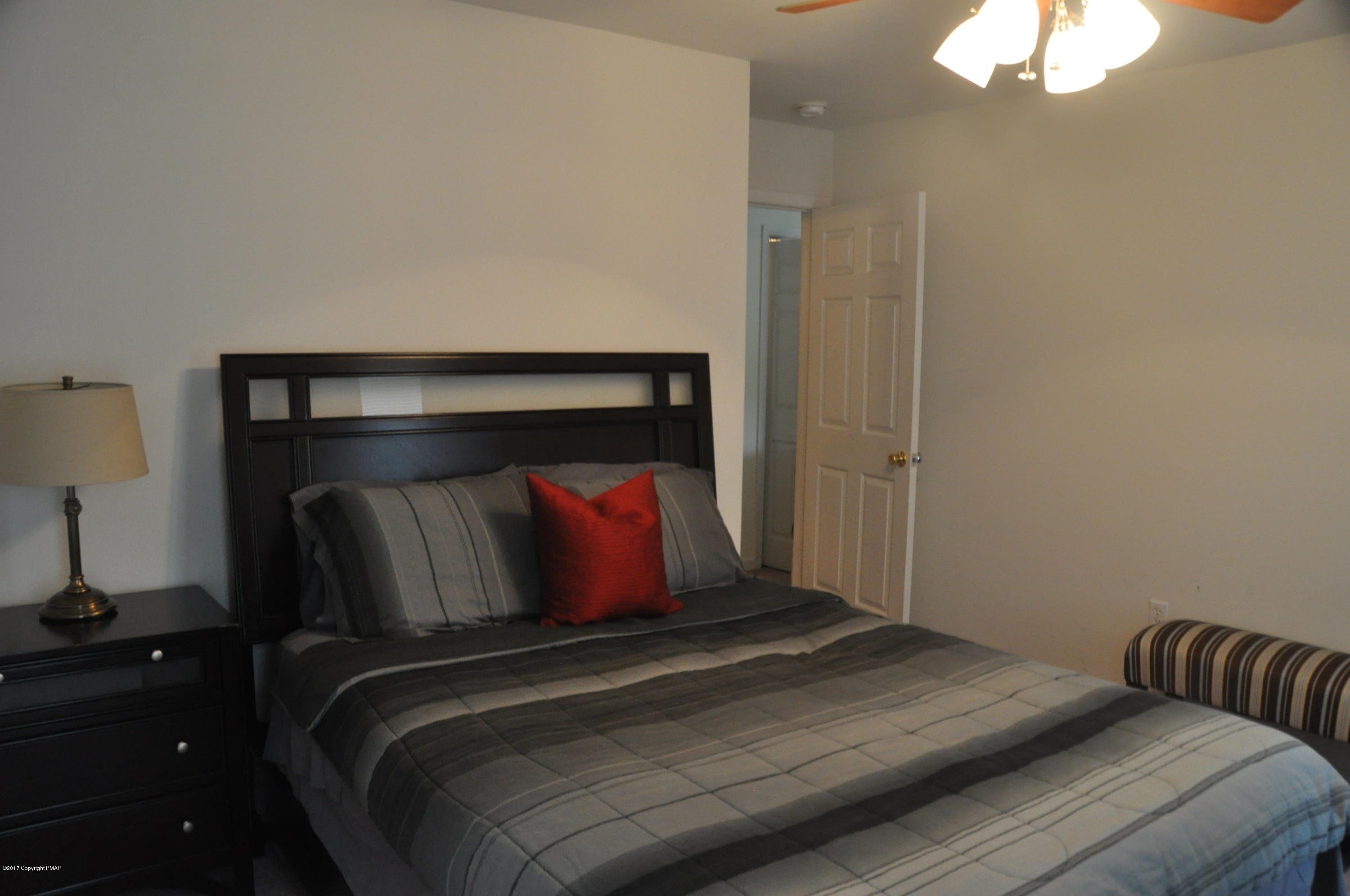 167 Sawmill Road Long Pond, PA 18334 - Photo 27 of 38 a bedroom with a bed and a lamp