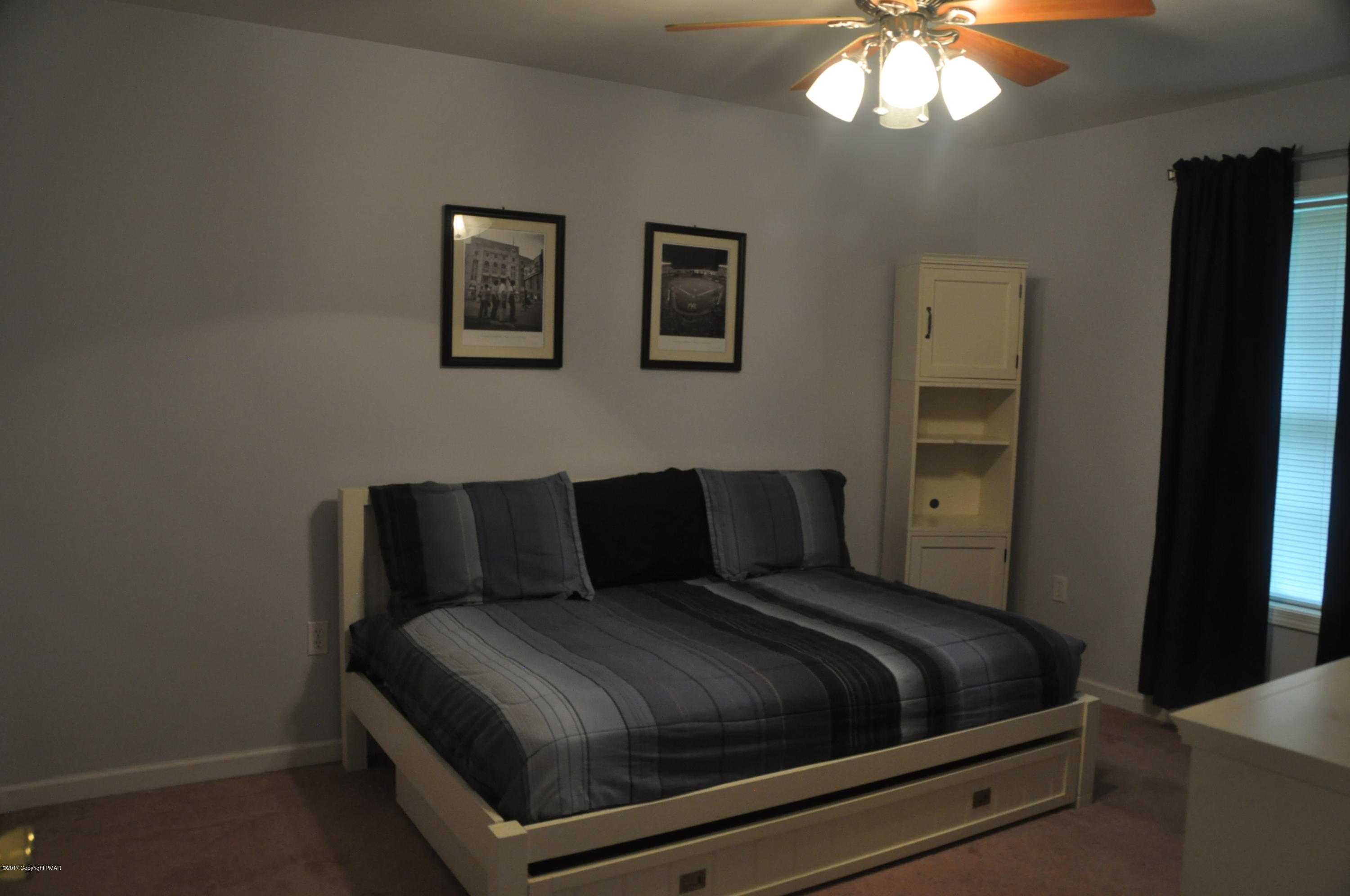 167 Sawmill Road Long Pond, PA 18334 - Photo 28 of 38 a bedroom with a bed and a chandelier