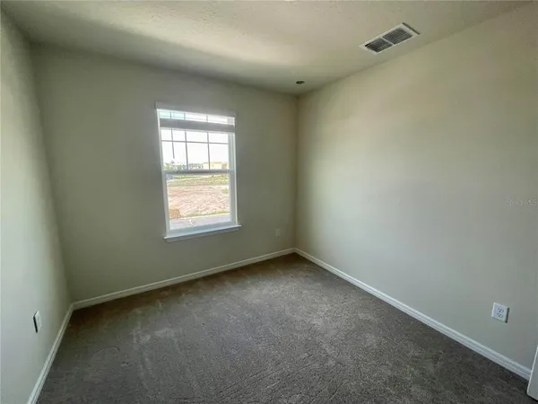 an empty room with closet and a ceiling fan