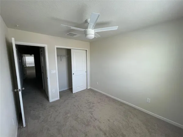 an empty room with a window and a fan