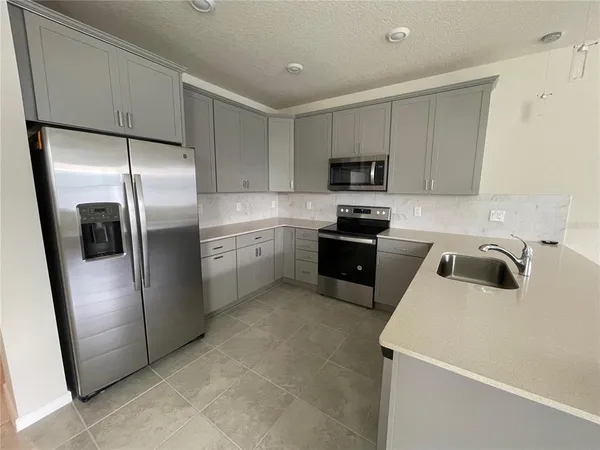 a kitchen with stainless steel appliances granite countertop a refrigerator sink and microwave