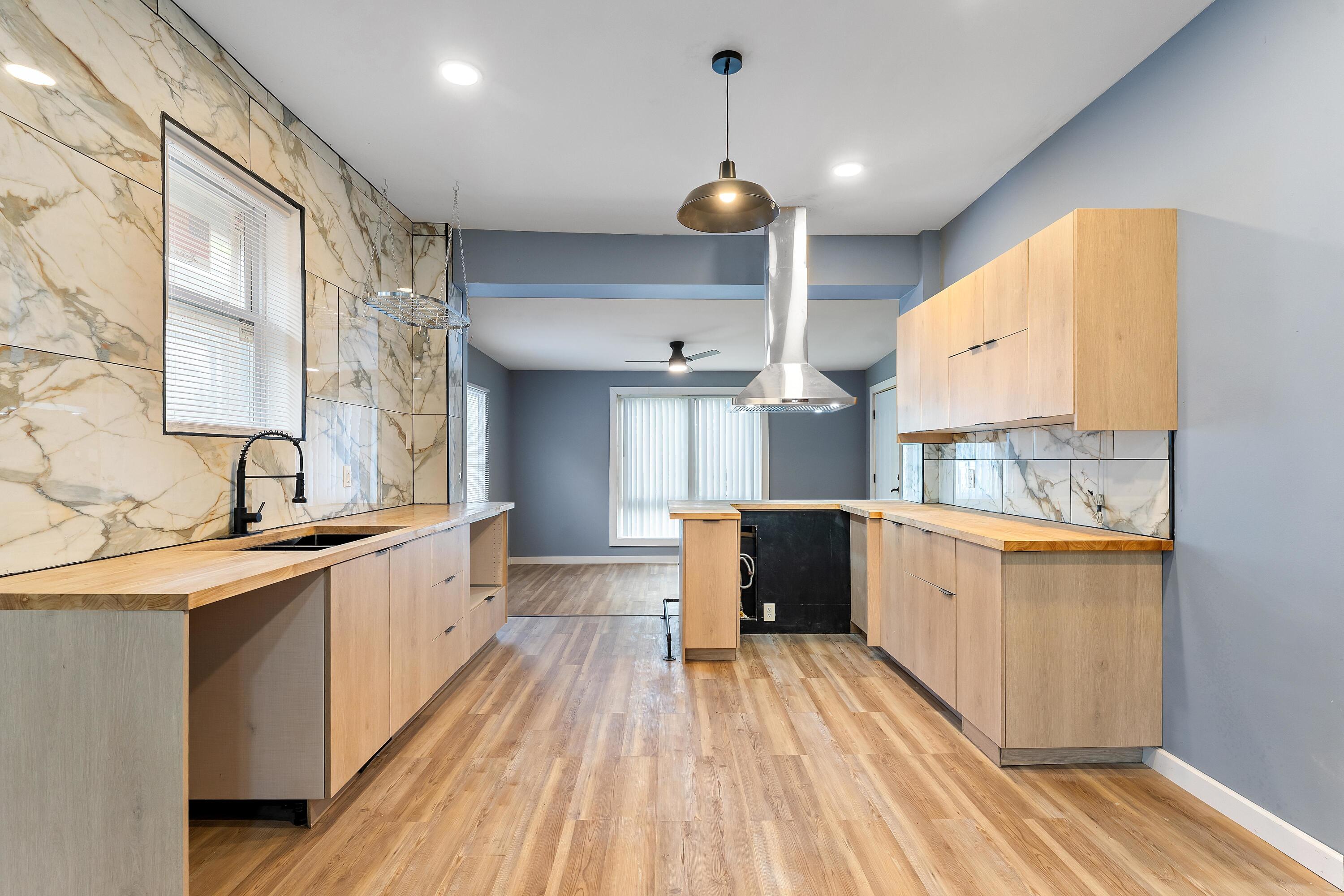 1317 Harrison Street Gary, IN 46407 - Photo 13 of 40 a large kitchen with stainless steel appliances a large counter top a sink a stove and wooden floors