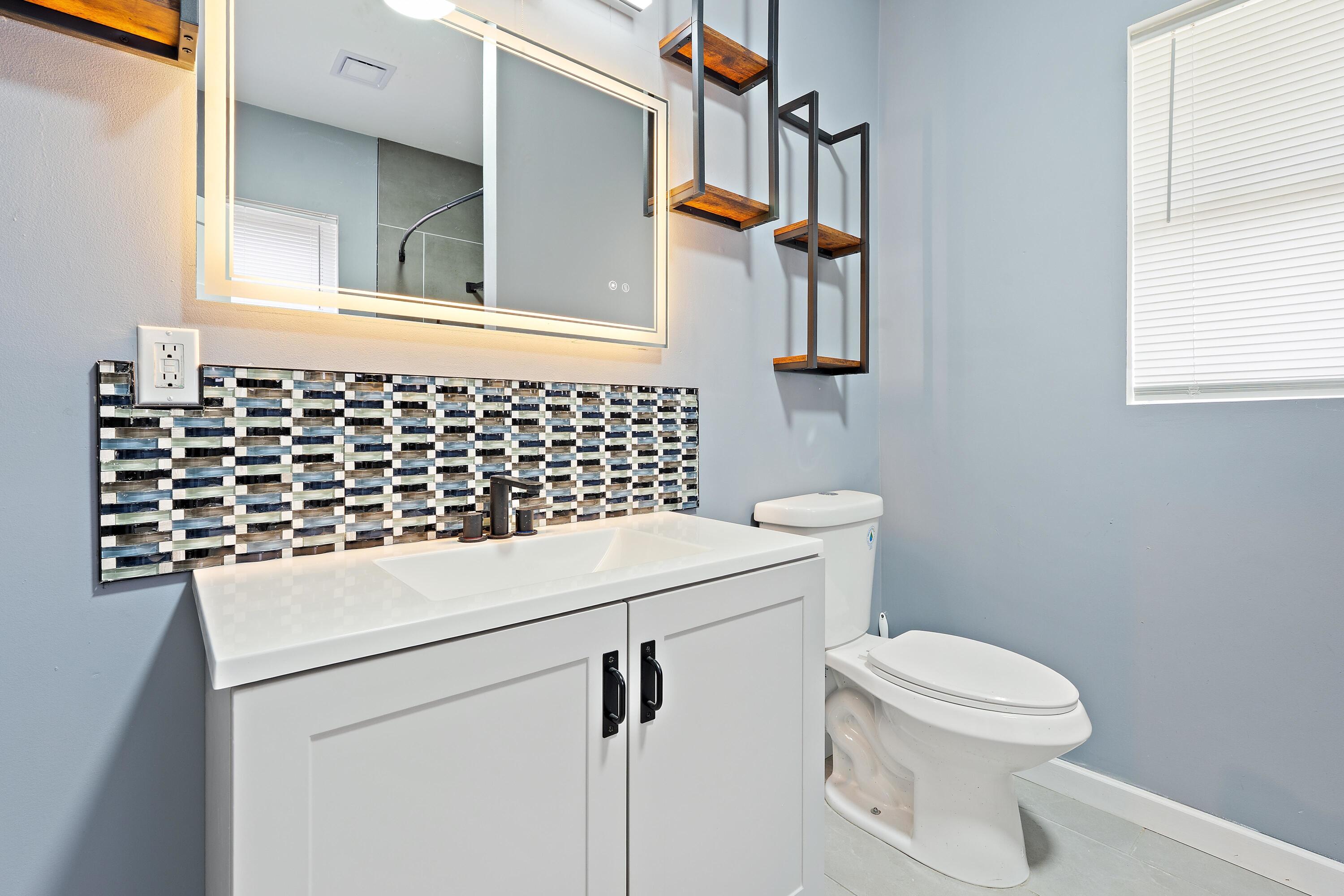 1317 Harrison Street Gary, IN 46407 - Photo 22 of 40 a bathroom with a sink a toilet and a mirror
