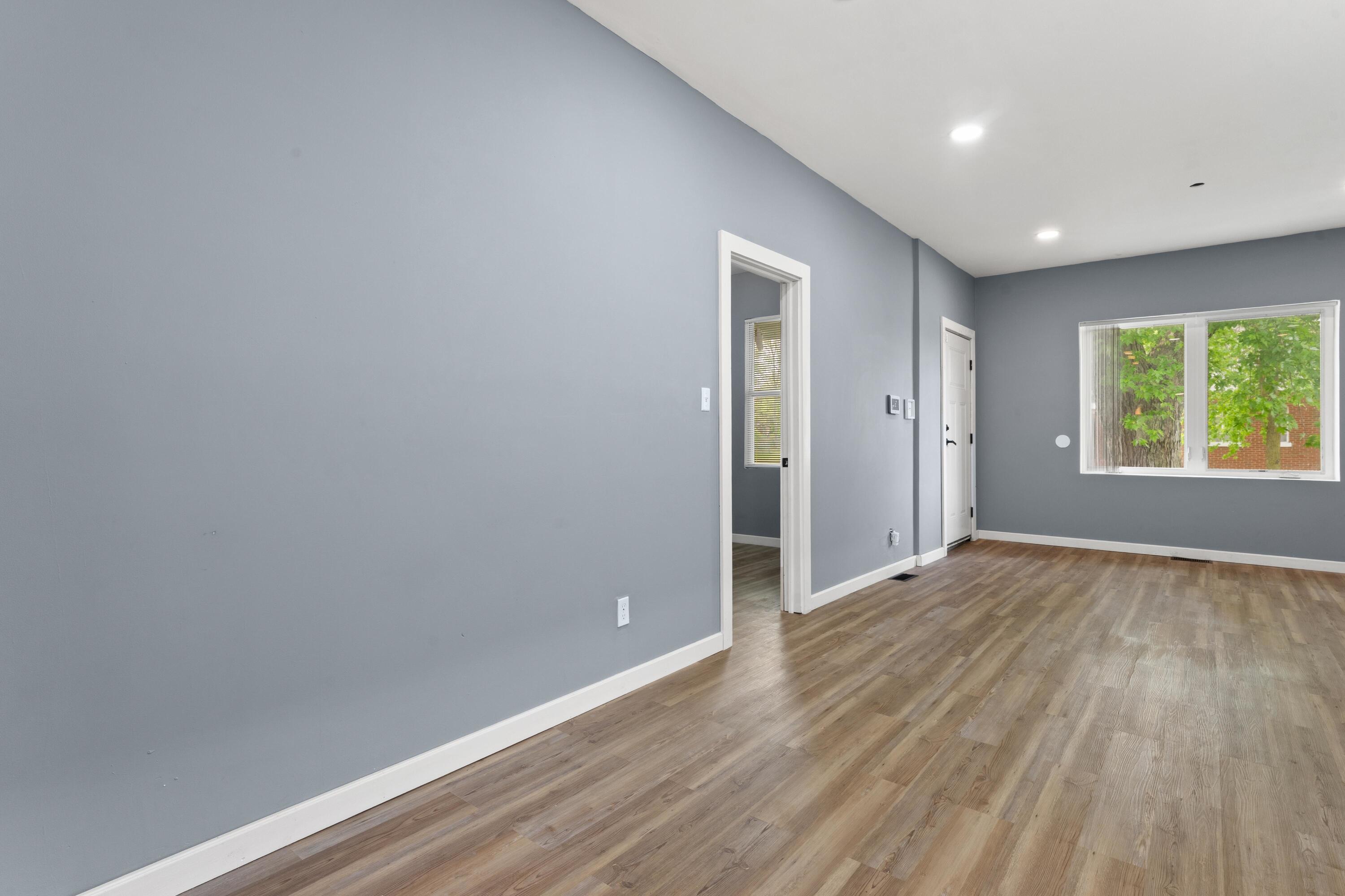 1317 Harrison Street Gary, IN 46407 - Photo 3 of 40 a view of an empty room with wooden floor and a window
