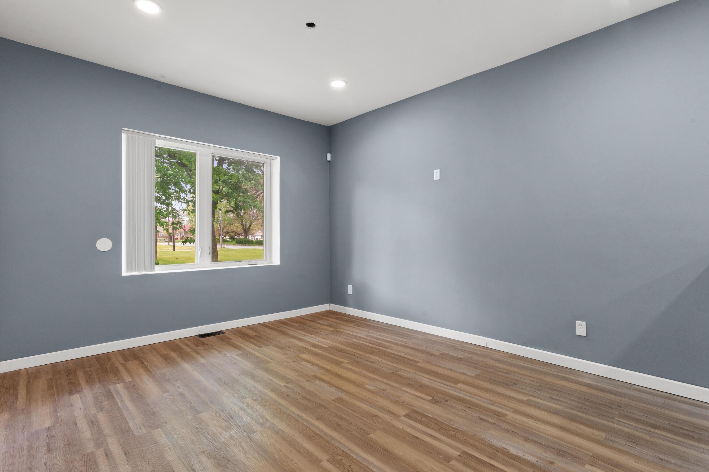 1317 Harrison Street Gary, IN 46407 - Photo 5 of 40 a view of an empty room with wooden floor and a window