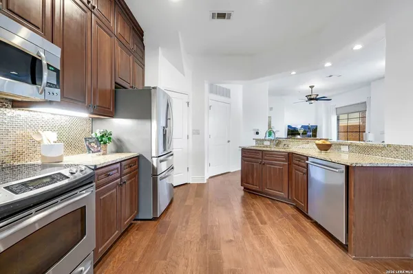 a large kitchen with stainless steel appliances and wooden cabinets