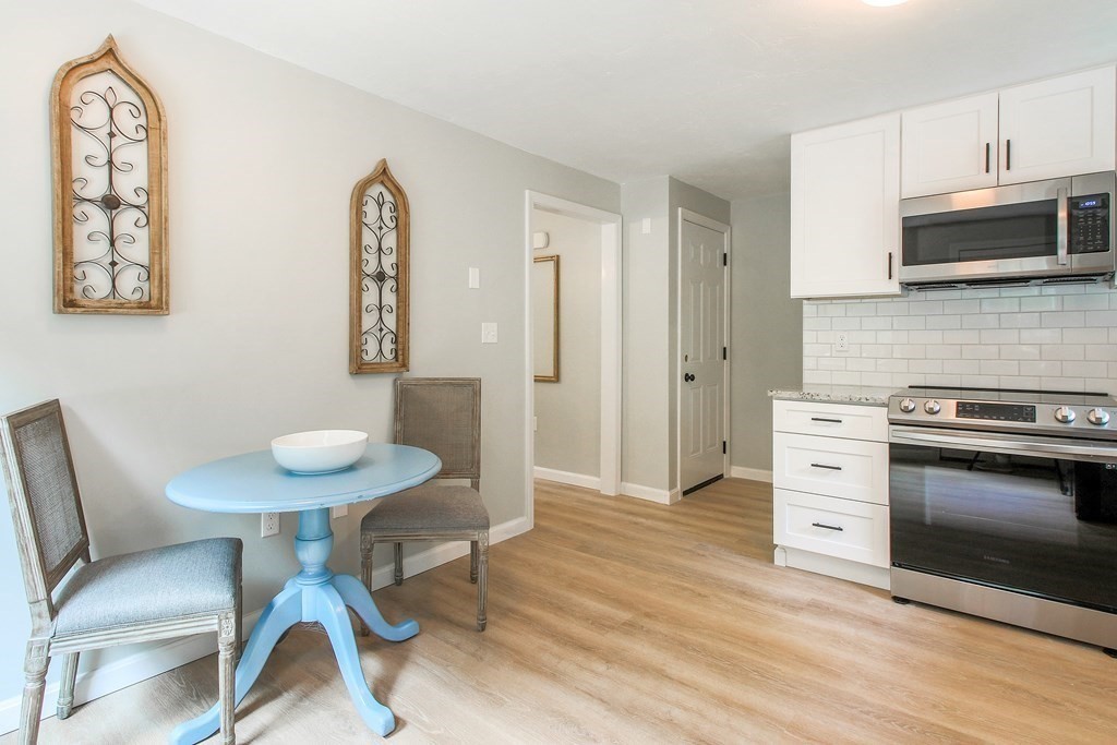 151 Harkness Road, Unit B North Smithfield, RI 02896 - Photo 19 of 36 a kitchen with stainless steel appliances a stove a table and chair