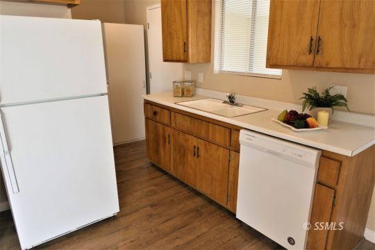 214 South Fire Opal Street Ridgecrest, CA 93555 - Photo 9 of 29 a kitchen with a sink and a refrigerator