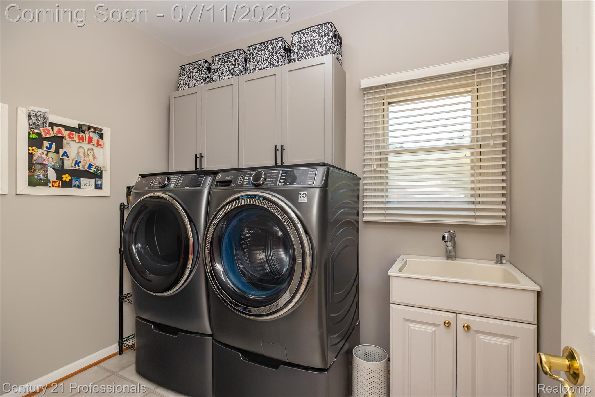 689 Woodfield Way Rochester, MI 48307 - Photo 22 of 61 Dedicated laundry space featuring a utility sink with white cabinetry, overhead gray shaker-style storage cabinets, and a window with horizontal blinds