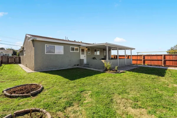 a backyard of a house with plants and wooden fence