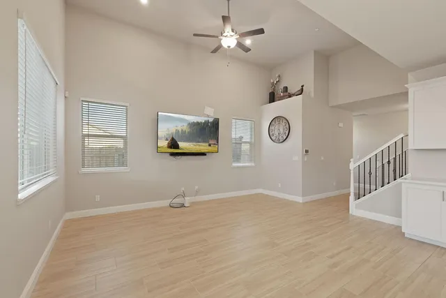 a view of an empty room with a window and wooden floor