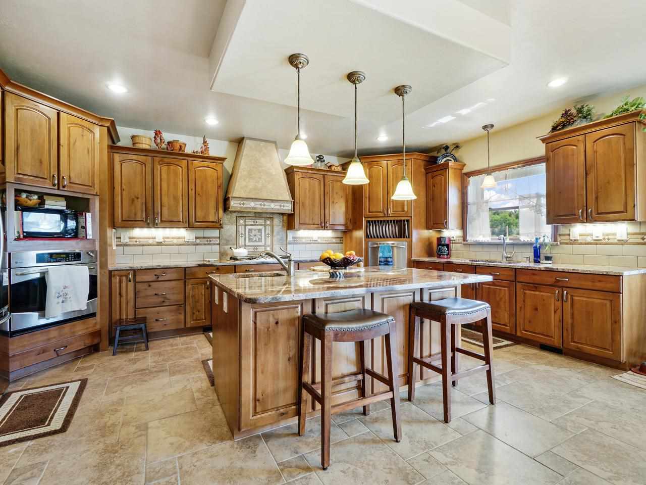 912 23 Road Grand Junction, CO 81505 - Photo 15 of 42 a kitchen with kitchen island granite countertop wooden cabinets a counter top space a sink stainless steel appliances and a center island