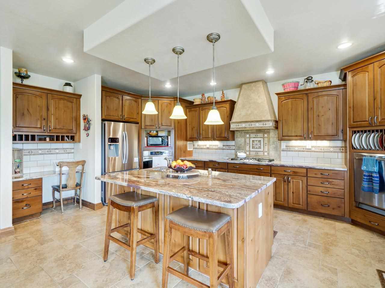 912 23 Road Grand Junction, CO 81505 - Photo 18 of 42 a kitchen with stainless steel appliances kitchen island granite countertop a table chairs sink and wooden cabinets