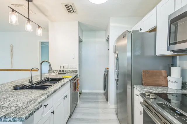 a kitchen with stainless steel appliances granite countertop a sink stove and refrigerator