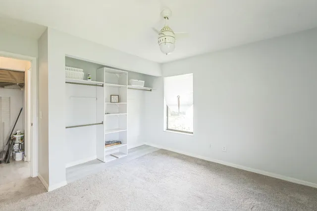 a view of a kitchen with refrigerator and white cabinets
