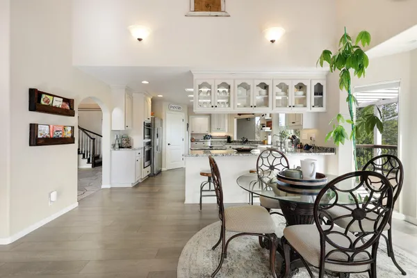 a living room with furniture a chandelier and kitchen view