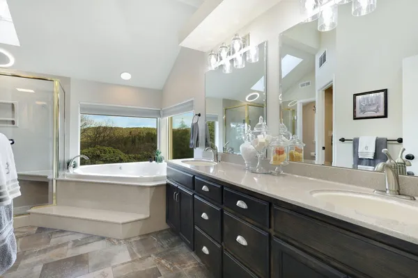 a bathroom with a granite countertop sink mirror and bathtub