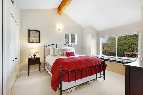 a bed sitting in a bedroom next to a window