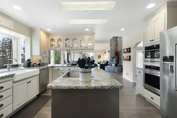 a kitchen with stainless steel appliances granite countertop a sink stove and refrigerator