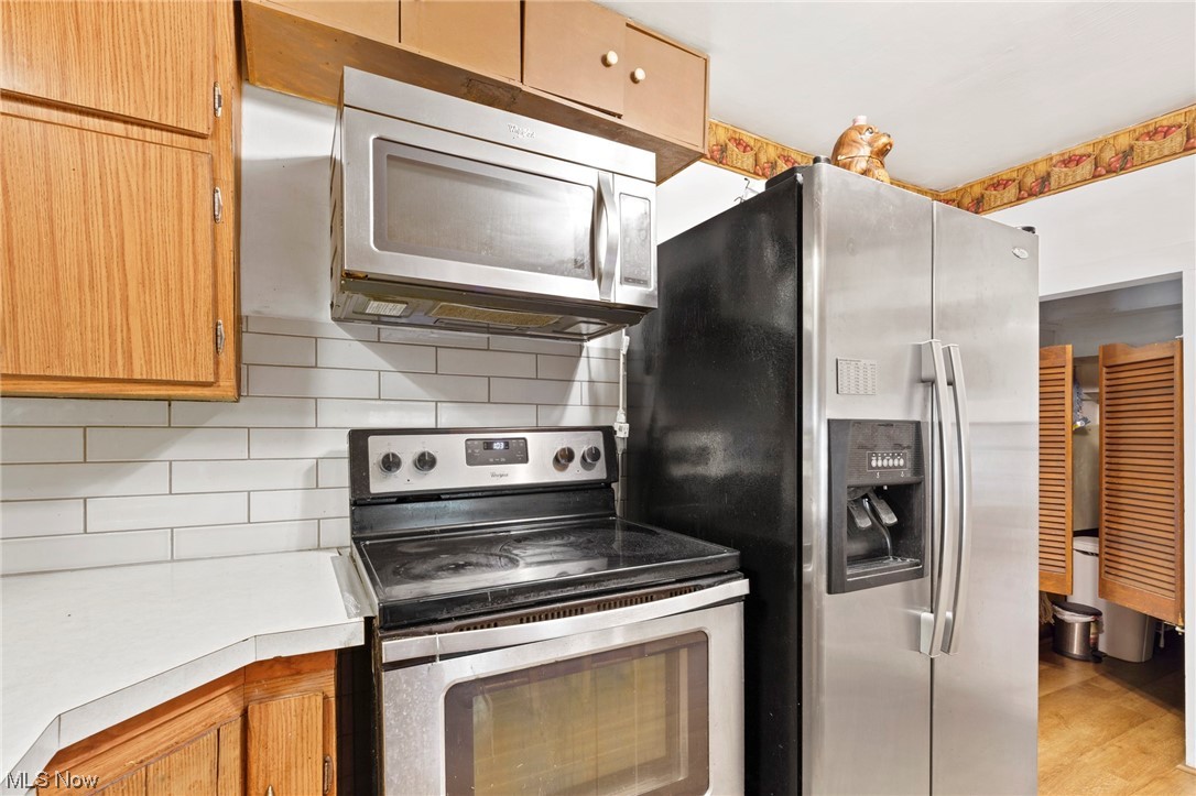 424 Sprague Road Berea, OH 44017 - Photo 7 of 24 Kitchen featuring tasteful backsplash, appliances with stainless steel finishes, and light hardwood floors