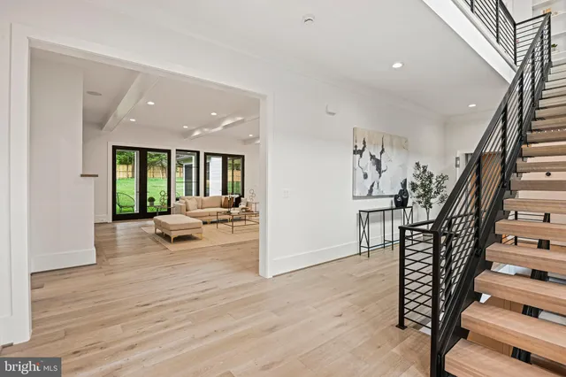 a view of a hallway with wooden floor and staircase