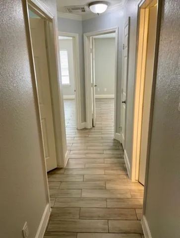 a view of a hallway with wooden floor and staircase