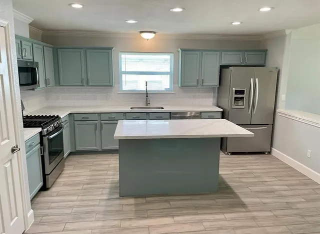 a kitchen with a sink stove and refrigerator
