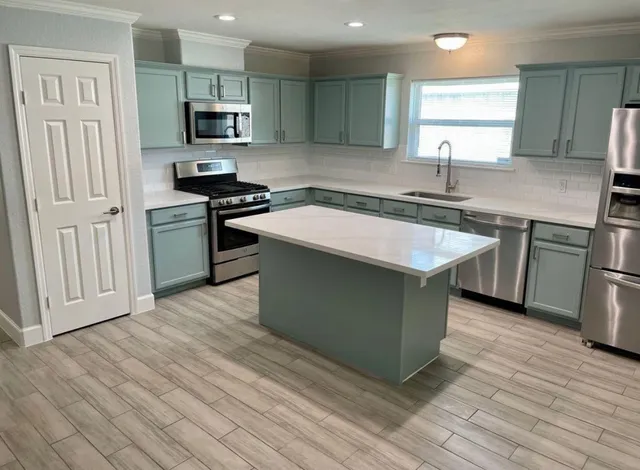 a kitchen with stainless steel appliances granite countertop a sink stove and refrigerator