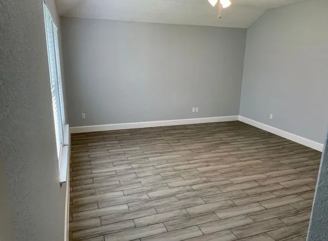 a view of an empty room with wooden floor