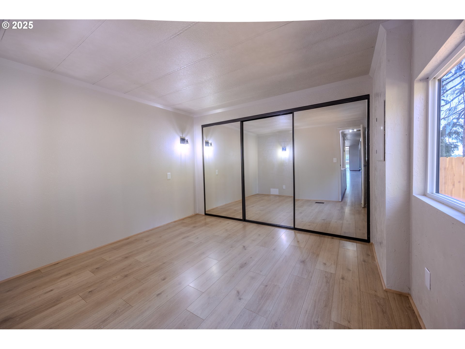 83763 Highway 101, Unit 21 Florence, OR 97439 - Photo 23 of 36 a view of an empty room with wooden floor and windows