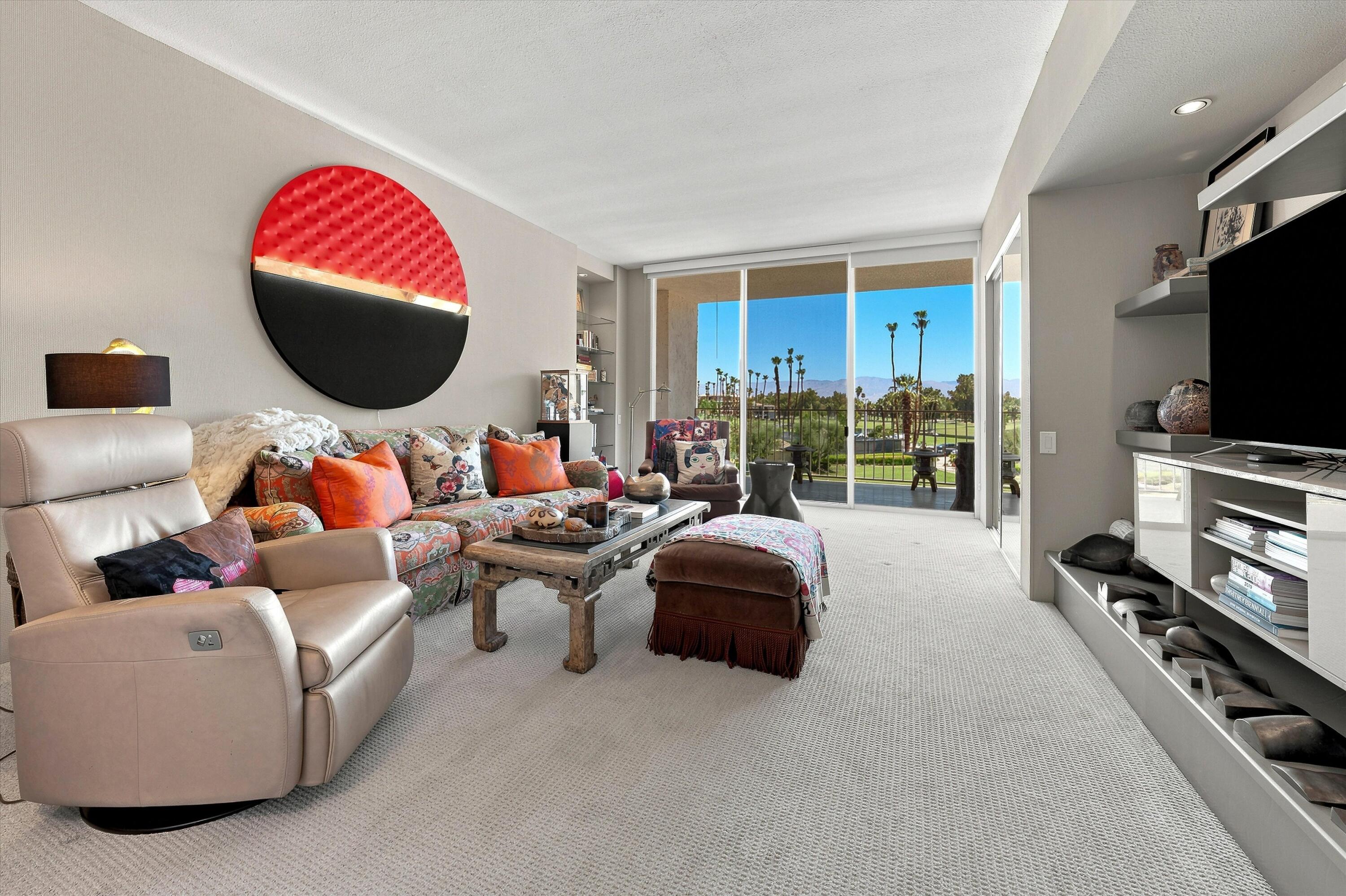 899 Island Drive, Unit 304 Rancho Mirage, CA 92270 - Photo 15 of 30 a living room with furniture a flat screen tv and a large window