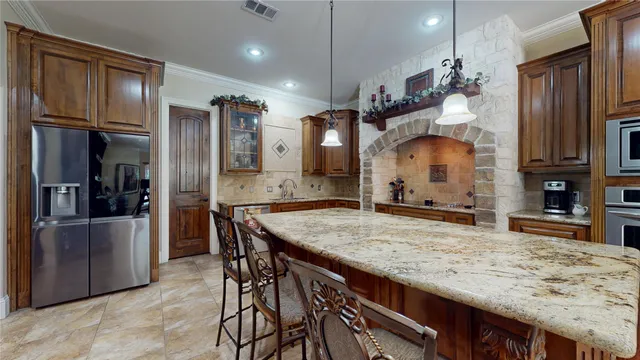a kitchen with stainless steel appliances granite countertop wooden cabinets a refrigerator and a sink