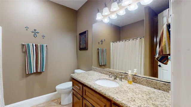a bathroom with a granite countertop double vanity sink and a mirror