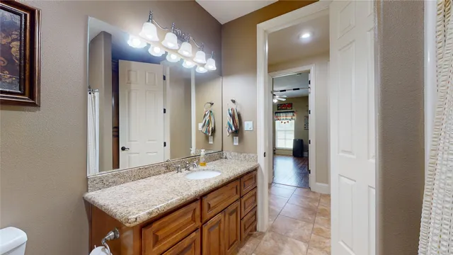 a bathroom with a granite countertop sink and a mirror