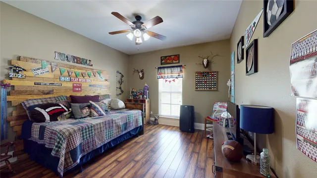 a spacious bedroom with a bed and wooden floor