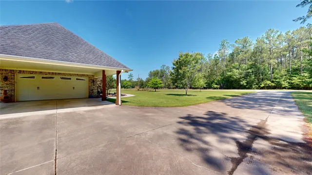 a view of a house with backyard and trees