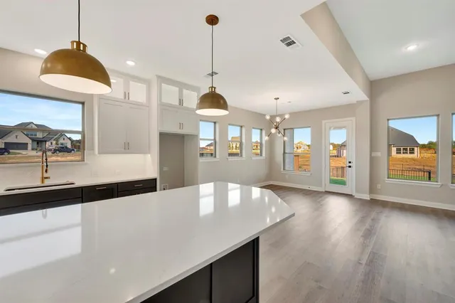 a large kitchen with stainless steel appliances kitchen island a large counter top and a wooden floors