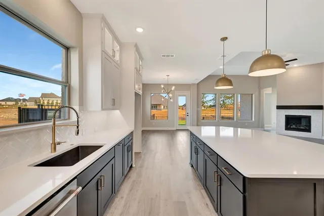 a view of an empty room with wooden floor fireplace and a window