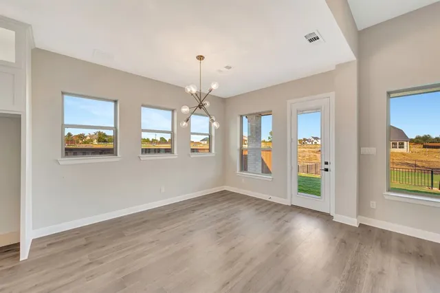 a large kitchen with stainless steel appliances kitchen island a large counter top a sink and wooden floor