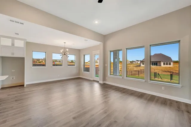 an empty room with windows and fireplace