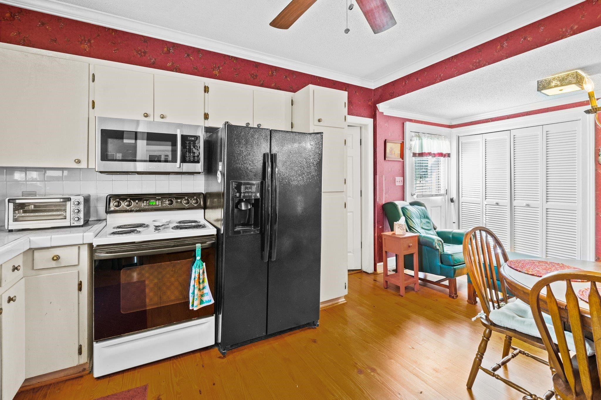 407 Old Post Road Erwin, NC 28339 - Photo 6 of 44 a kitchen with stainless steel appliances a stove a refrigerator and a dining table with chairs