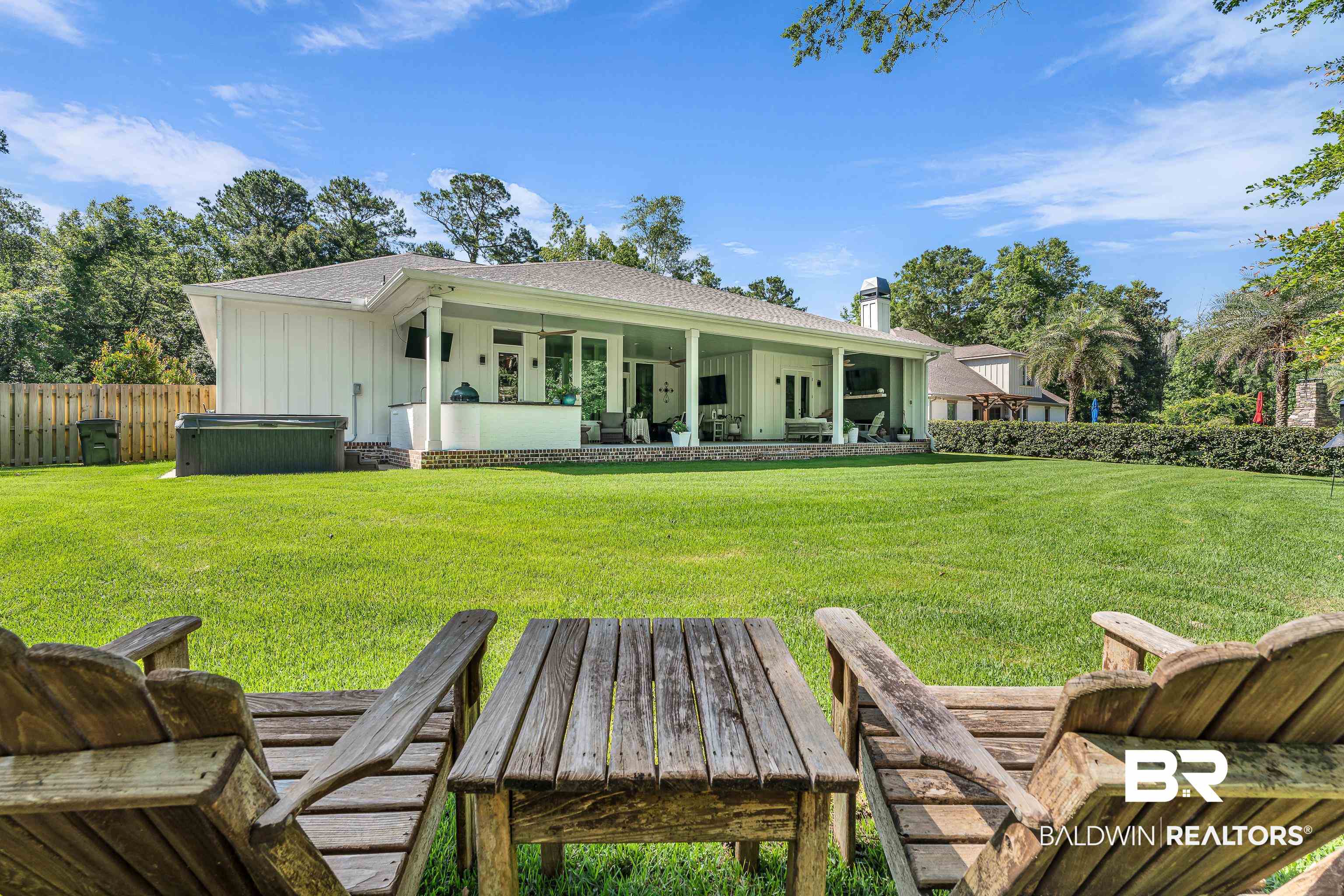 17541 Polo Ridge Boulevard Fairhope, AL 36532 - Photo 18 of 19 Expansive rear lawn with a covered patio, a visible hot tub, and mature landscaping