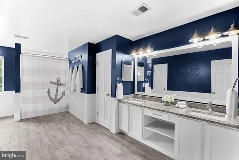 a bathroom with double vanity and a mirror