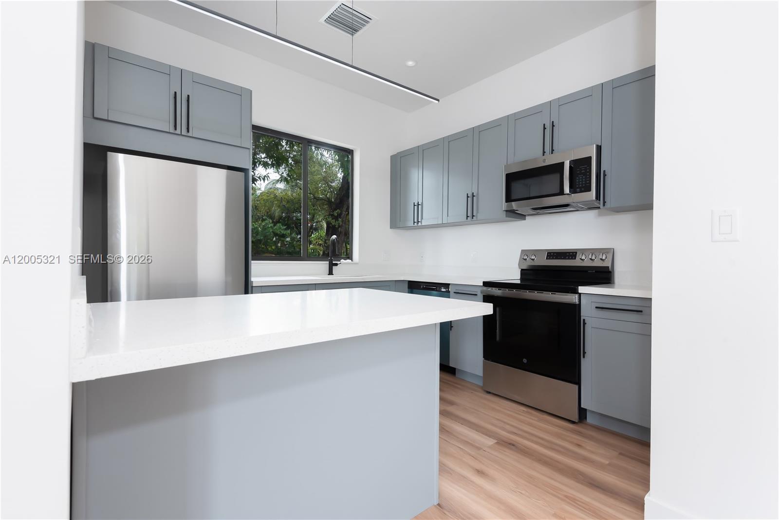 4517 Northwest 3rd Street, Unit 4517 Miami, FL 33126 - Photo 8 of 12 a kitchen with stainless steel appliances a microwave sink and refrigerator