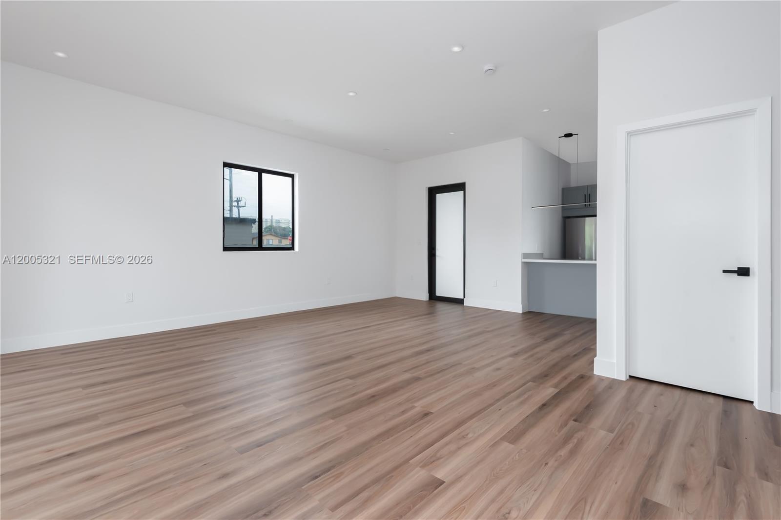 4517 Northwest 3rd Street, Unit 4517 Miami, FL 33126 - Photo 9 of 12 an empty room with wooden floor and windows