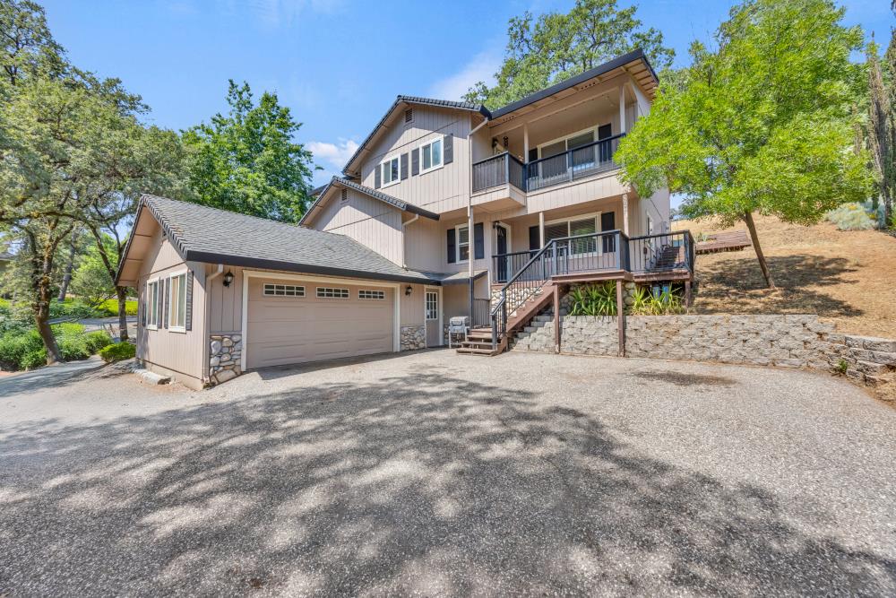 a view of a house with a yard and large tree