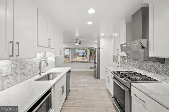 a kitchen with stainless steel appliances granite countertop a sink and a stove