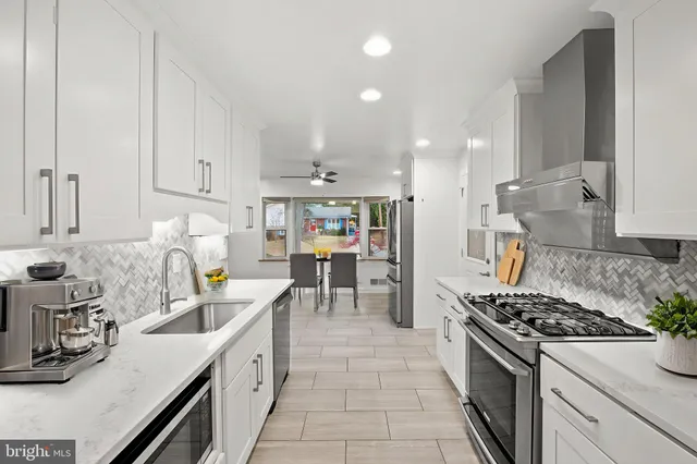 a kitchen with granite countertop a sink stove and cabinets